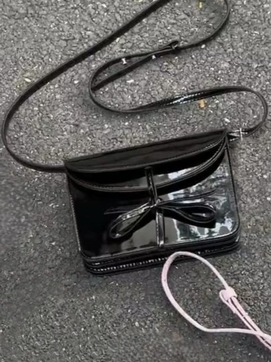 Elegant Black Crossbody Phone Pouch With Glossy Finish And Bow Accent