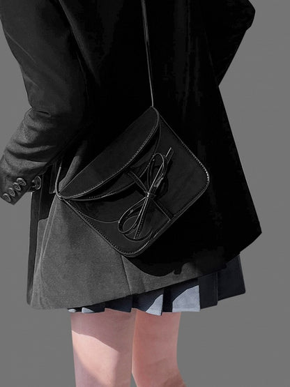 Elegant Black Crossbody Phone Pouch With Glossy Finish And Bow Accent