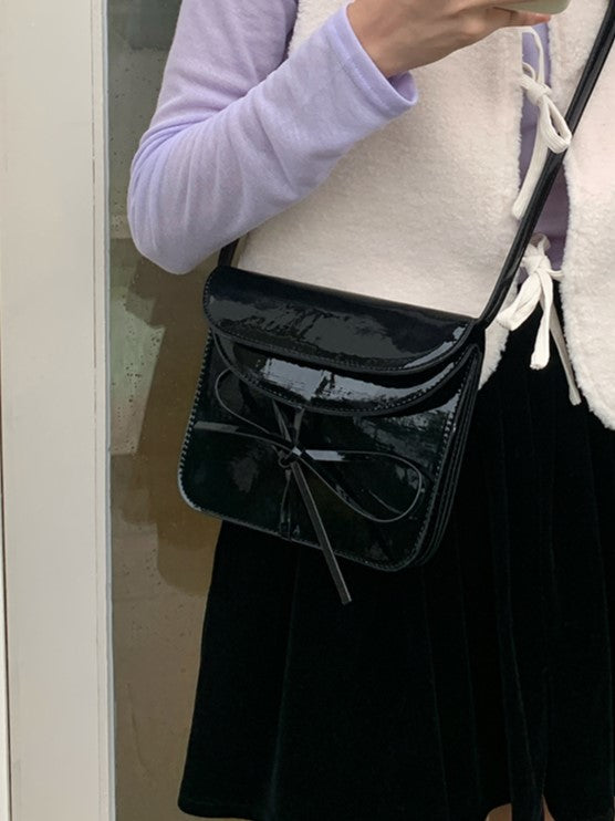 Elegant Black Crossbody Phone Pouch With Glossy Finish And Bow Accent